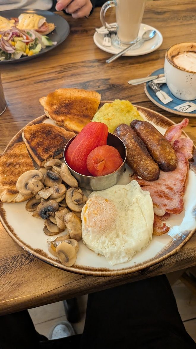 Full English breakfast with coffee on a wooden table